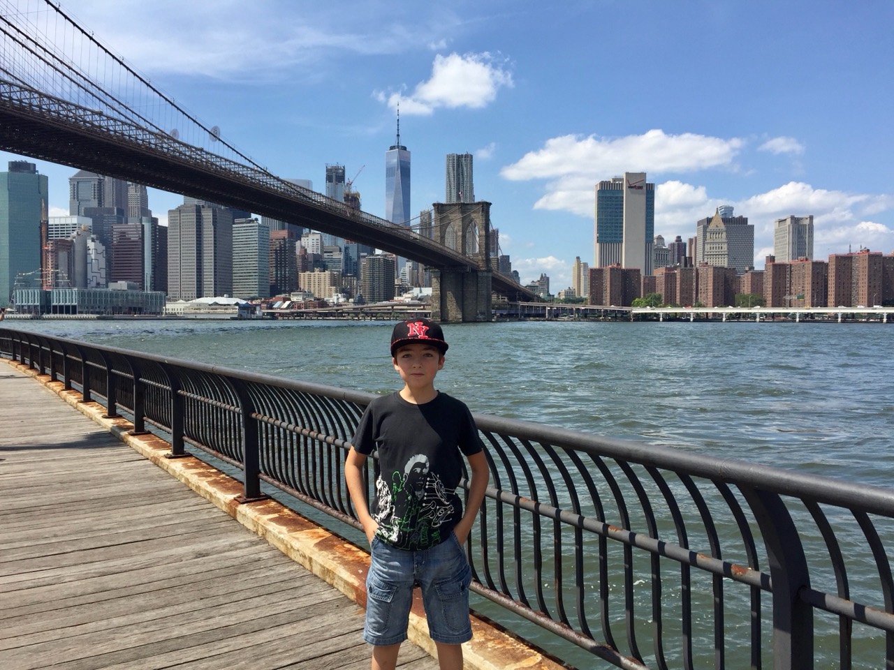 A younger Roméo in New York, with the Brooklyn Bridge and Manhattan